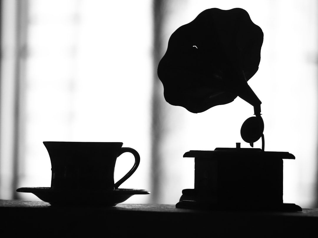Silhuett av en grammofon och kaffekopp i morgonljus